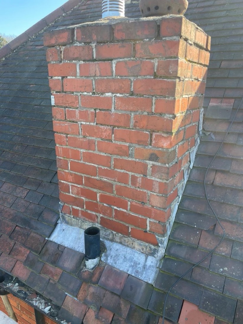 Repointed brick chimney stack with new flashing