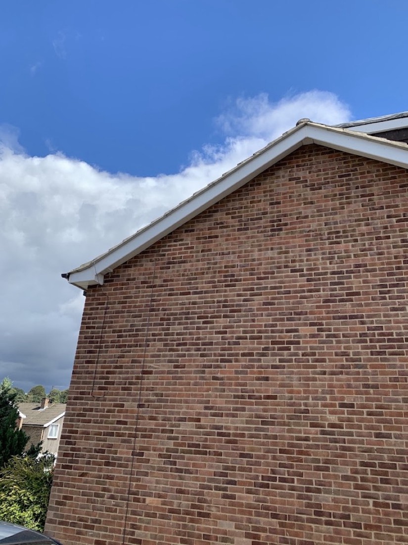 Clean gable end with new white bargeboard against blue sky
