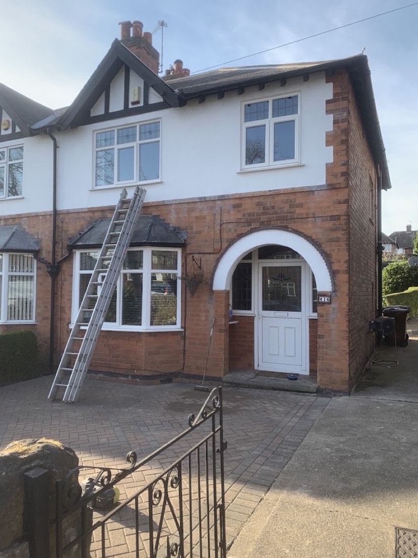 Terraced house with a ladder up to the bay roof, work in progress